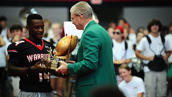 Pelham Mayor Gary Waters, right, presents the Game Ball trophy to Thompson High School football player Alijah Steele during a Sept. 11 pep rally at THS. (Reporter Photo/Neal Wagner)