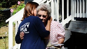 Suzi Daniels, left, and Carolyn Ledbetter embrace after Daniels delivered a new tiller to replace one stolen from Ledbetter a few weeks ago. (Reporter Photo/Neal Wagner)