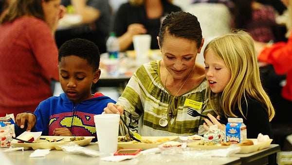 Cameron Kennedy, left, joins Wendy Stewart and her daughter, Harper, during Meadow View Elementary School's Thanksgiving lunch on Nov. 18. (Reporter Photo/Neal Wagner)